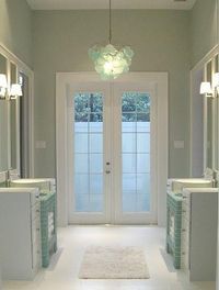 a large bathroom with two sinks and mirrors on either side of the door to another room