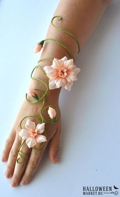 a woman's hand with flowers on it and green string attached to the wrist