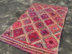 a multicolored rug is laying on the ground with no one around it,