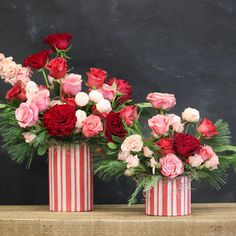 two red and white striped vases filled with flowers