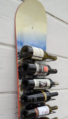 a snowboard mounted to the side of a wall with wine bottles