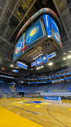 the inside of a basketball arena with blue and yellow seats on it's sides