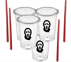 four plastic cups with stickers on them and one has a face drawn on it