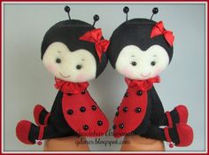 two little stuffed animals are sitting on a table together, one is wearing a red bow and the other is black with white dots