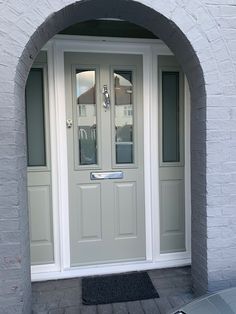 a white door with two glass panels and a black mat on the outside of it