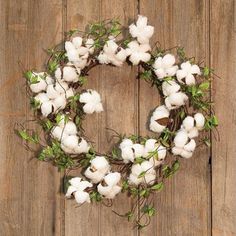 a wreath made out of cotton sitting on top of a wooden table