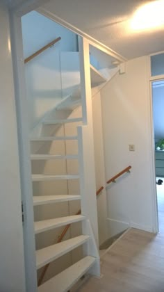 there is a white stair case in the room that has no carpet on the floor