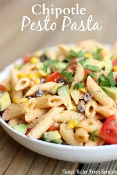 a white bowl filled with pasta salad on top of a wooden table