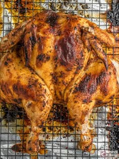 a whole chicken sitting on top of a grill grates covered in oil and grease