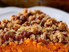 a close up of a piece of cake on a white plate with pecans and crumbs