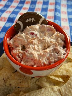 a football shaped dip in a bowl with chips