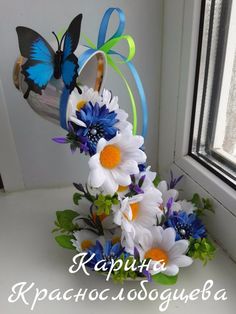 a vase with flowers and butterflies in it