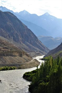 a river running through a valley surrounded by mountains