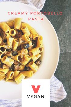 a white plate topped with pasta covered in sauce and mushrooms next to a blue towel