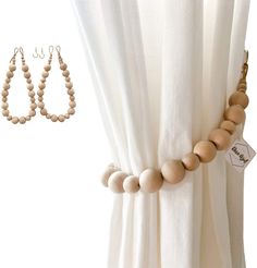 two wooden beads are hanging from the curtain