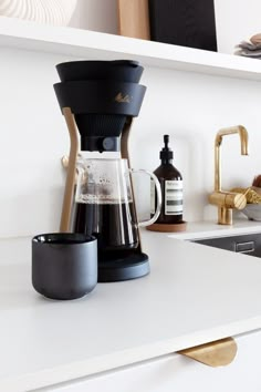 a coffee maker sitting on top of a white counter