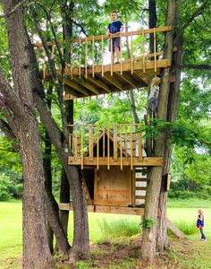 a young boy standing on top of a tree house