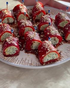 there are many appetizers with toothpicks in them on the plate, ready to be eaten