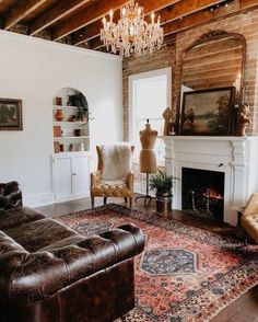 a living room filled with furniture and a chandelier hanging from the ceiling next to a fire place