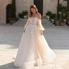 a woman in a wedding dress is standing outside