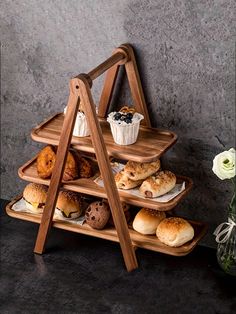 three tiered wooden tray with pastries on it