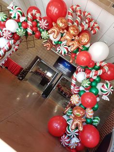 the balloon arch is decorated with candy canes and candies