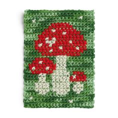 a crocheted square with red mushrooms on it