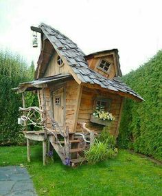 a small wooden house sitting on top of a lush green field