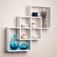 the wall shelf is decorated with blue vases and white shelves on each one side