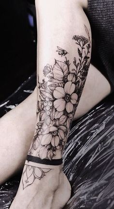 a woman's arm with flowers on it and a black band around the wrist