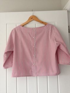 a pink and white striped shirt hanging on a wall