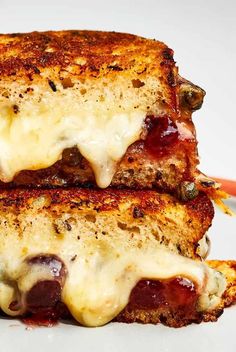 two grilled cheese sandwiches stacked on top of each other with sauce and melted cheese