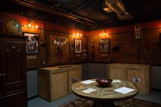 a room with wooden cabinets and pictures on the walls, including a bowl sitting on top of a table