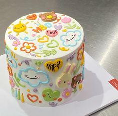 a decorated cake sitting on top of a white table next to a metal countertop