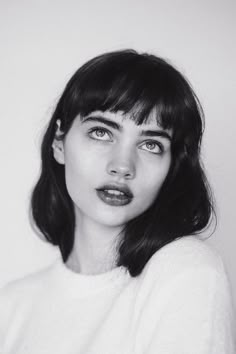 a black and white photo of a woman with dark lipstick on her lips looking at the camera