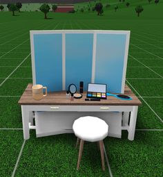 a computer desk sitting on top of a green field next to a white stool and table