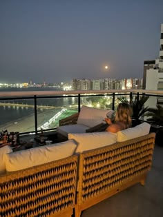 a woman sitting on top of a couch next to a balcony