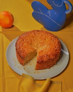 a piece of cake on a plate next to an orange