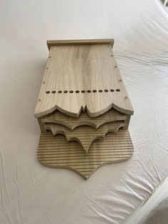 a wooden object sitting on top of a white sheet