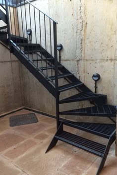 a set of black metal stairs next to a wall