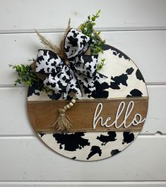 a black and white cow print sign with the word hello on it