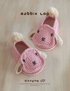 two crocheted slippers with pom - poms on them