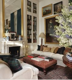 a living room filled with furniture and pictures on the wall above it's fireplace