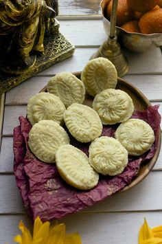 there are many cookies on the plate and some flowers in the bowl next to it