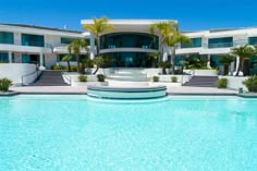 a large white house sitting next to a swimming pool with steps leading up to it