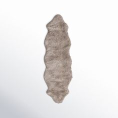 an animal fur rug is hanging on the wall in front of a white background with room for text