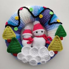 a crocheted christmas wreath with two snowmen