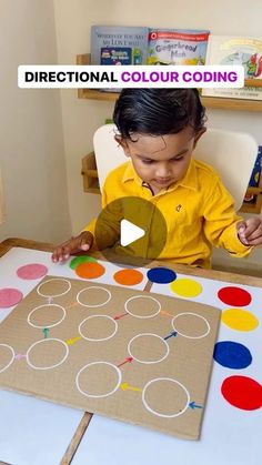 a little boy that is sitting at a table with some paper circles on the floor