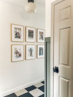 a hallway with pictures on the wall and a checkered floor in front of it