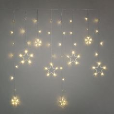 the stars are hanging from the ceiling in front of the white wall with lights on it